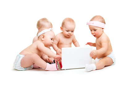 Vier interessierte Babys an einem Laptop.